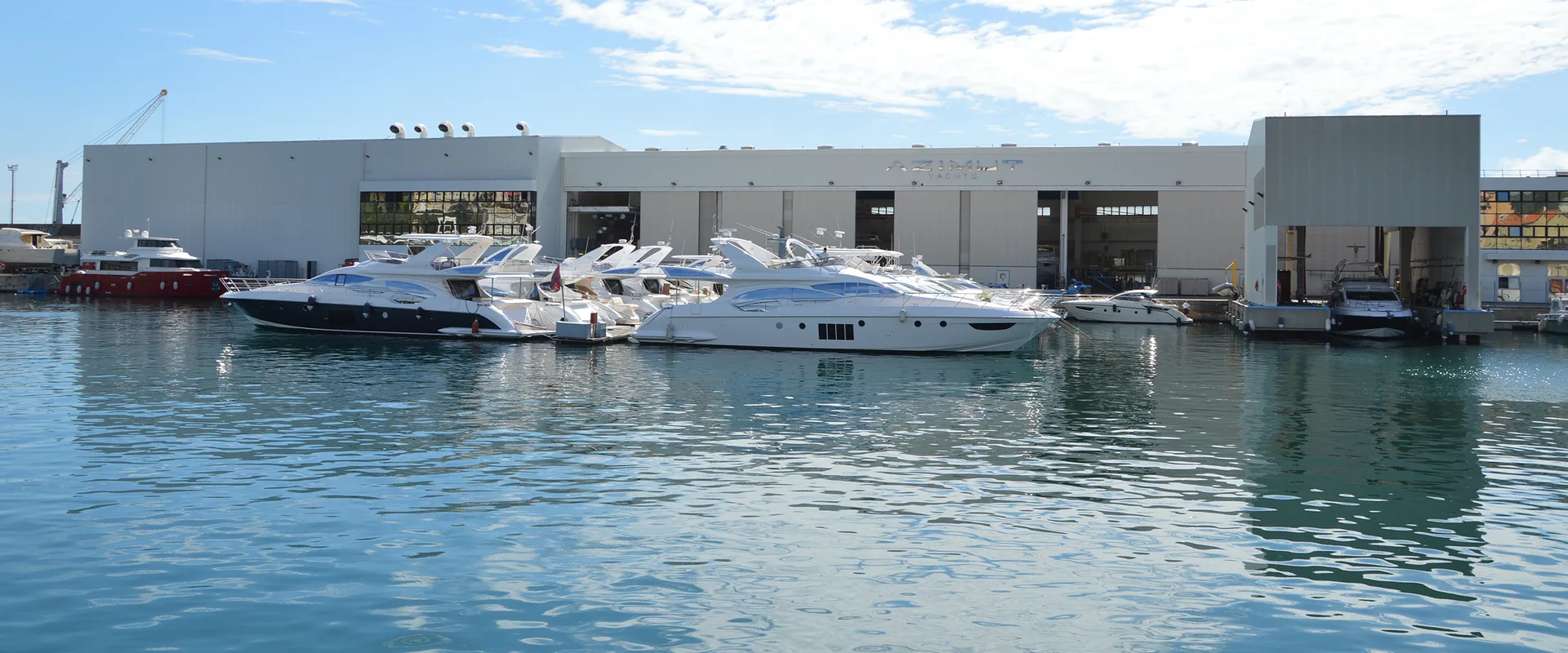 Azimut Yachts production hall with the fleet moored alongside the quay