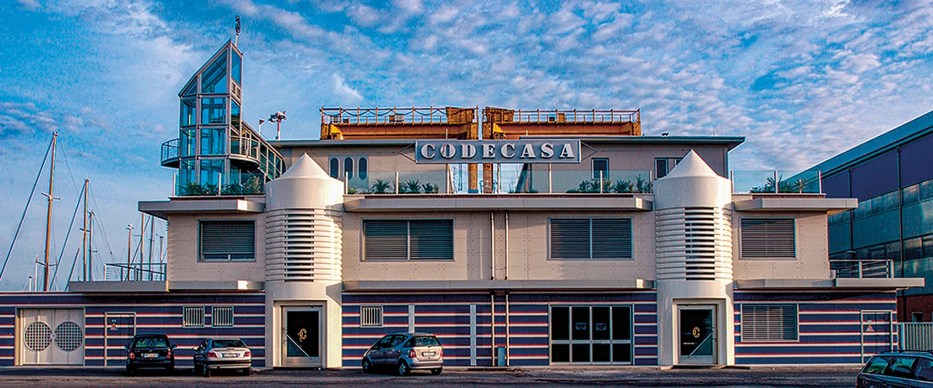 Codecasa headquarters at Viareggio — the branded yard building with the gantry crane behind and masts alongside